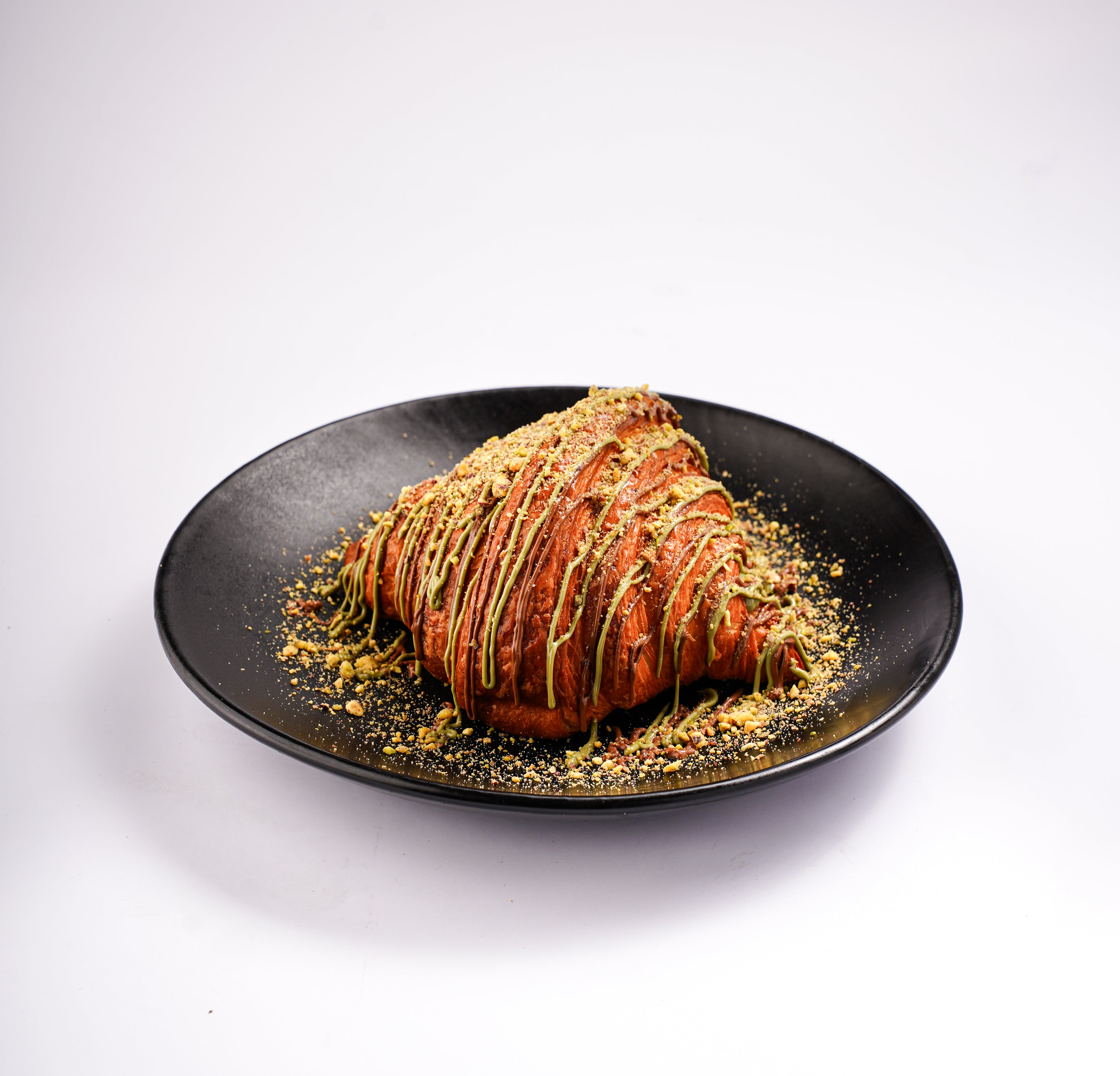 Pistachio kunafa croissant topped with pistachio and kunafa crumbs at The Croissant Guy Karachi